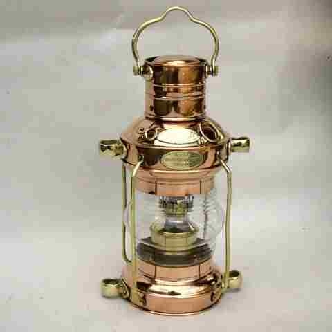Product Description: This classic 12” tall anchor lamp has been used on sailing ships for hundreds of years. Includes LED tap light.</br></br>This anchor lamp is hand machined in pure heavy-gauge copper with brass trim. The Fresnel style lens is made to magnify the oil lamp light to be visible for 20 nautical miles. The anchor lamp is named for it's use. A white light is required to be displayed at the tallest mast on all vessels at anchor or under way at night. These oil burning lanterns were made to be lit and hoisted to the top of the mast with one rope tied to the handle and 2 ropes through the brass guides to keep it from swaying as the ship rolled with the sea.</br></br>They can burn for up to 6 hours before refilling. Today electric lights are used but oil lamps such as this one are still kept on-board ships and yachts in case of electrical failure.</br> 12" Copper & Brass Anchor Lamp