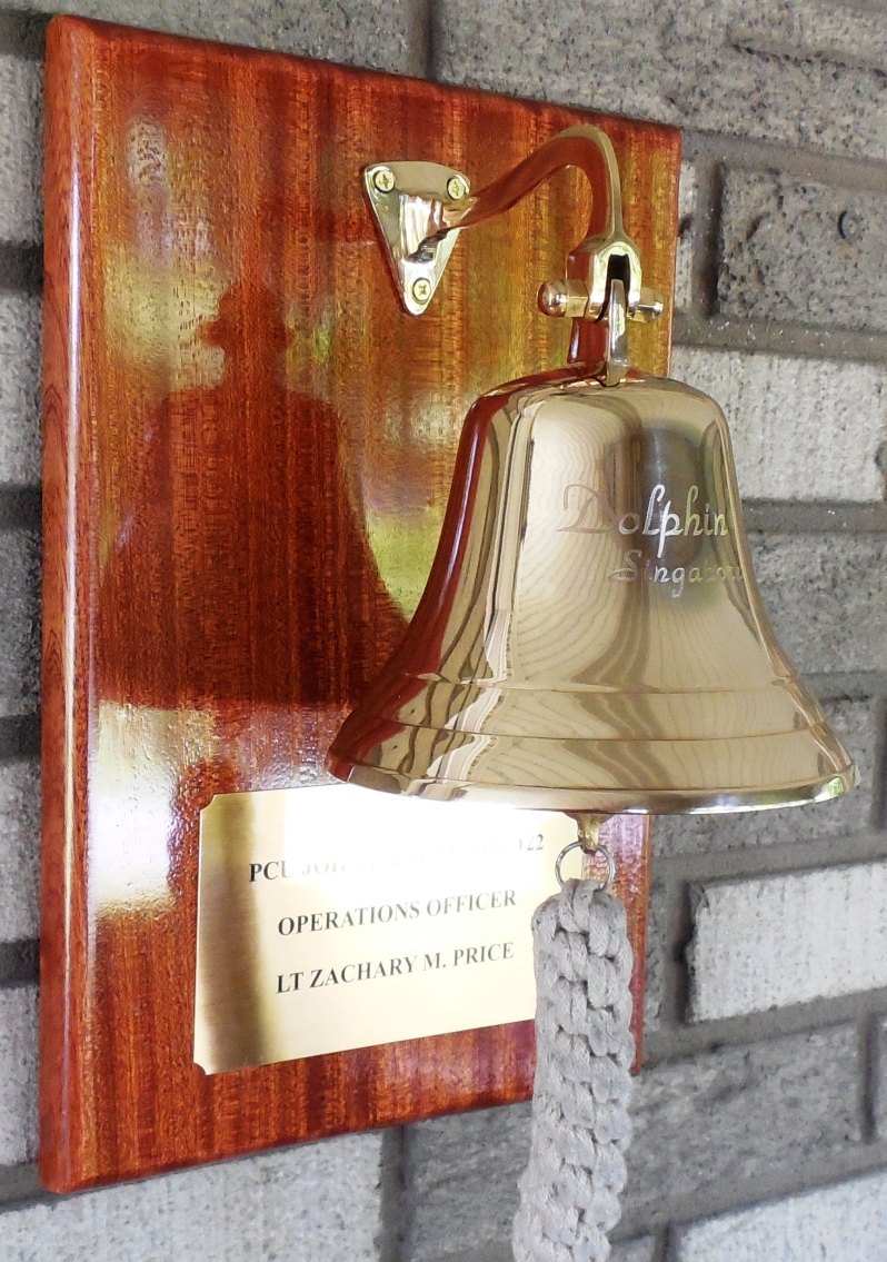 Product Description: 6” solid brass ship’s bell mounted on a solid hardwood plaque with brass plate. Available in three types of hardwood. Solid Mahogany, Red Oak and Dark Oak. (Mahogany plaque shown.) Both the brass bell and the brass plate can be engraved with whatever inscription you would require. Cost is the same regardless of the number of characters and/or logo. Awards such as this give a special lasting impression and carry a special meaning to all involved. Email your engraving to merchandise@seahistory.org. Mahogany plaque measures 12″ high x 9-1/2″ wide</br> Vertical Presentation Plaque with Brass Bell